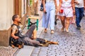 ÃÂ¡ity landscape - view of a beggar sitting on a stone pavement in the Old Town of Prague